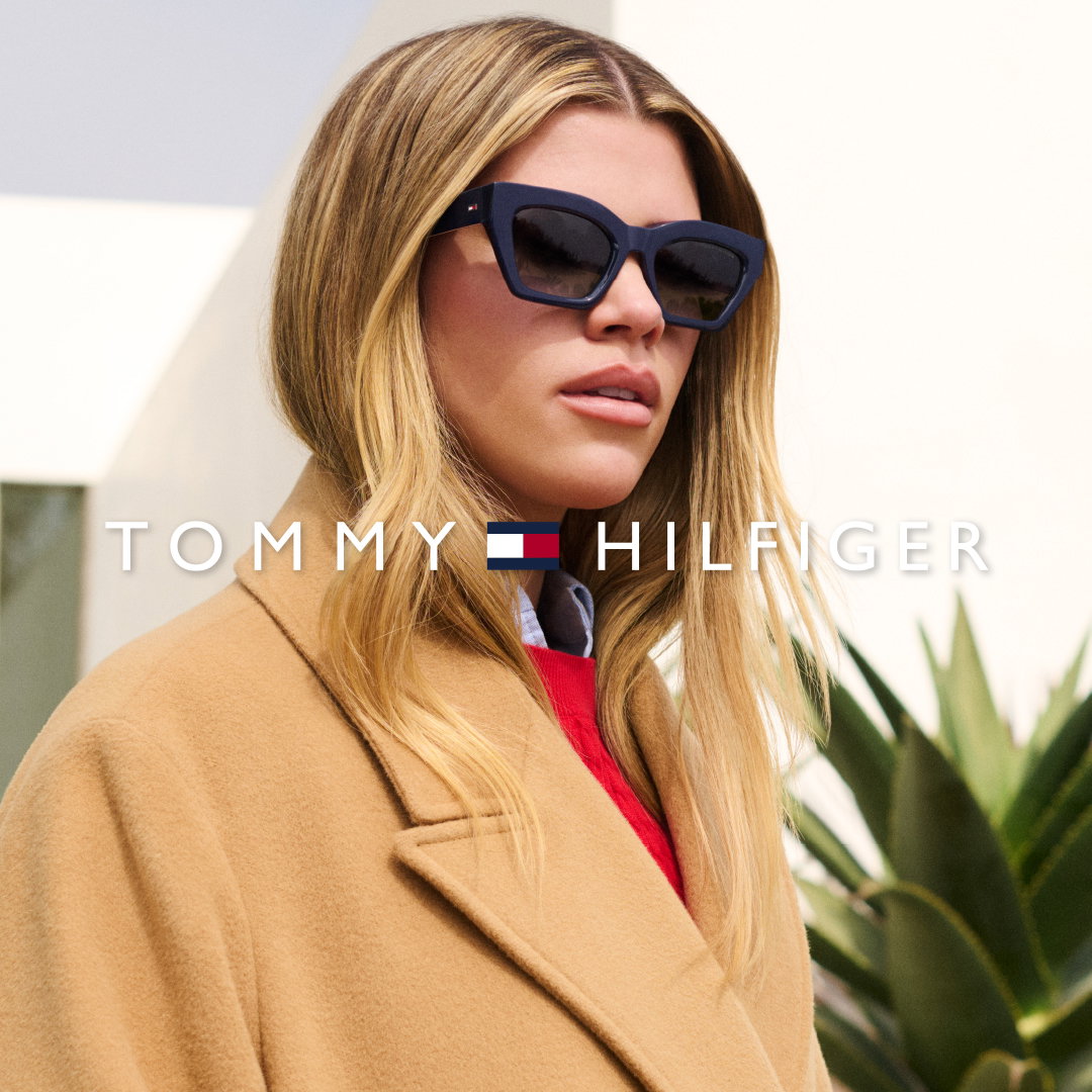 Das Bild zeigt eine blonde Frau mit einer Tommy Hilfiger Sonnenbrille in einem beigen Mantel.
